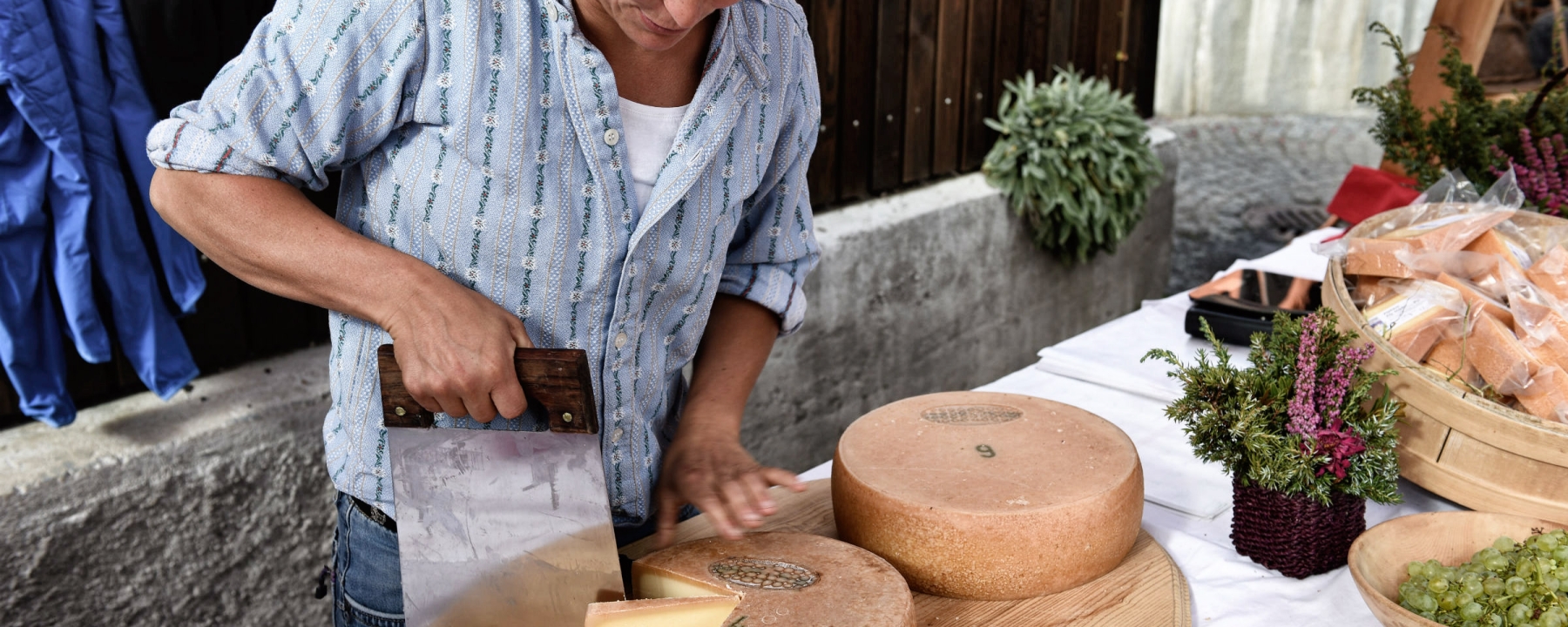 Bäuerin schneidet Alpkäse am Markt vom Alp Spektakel