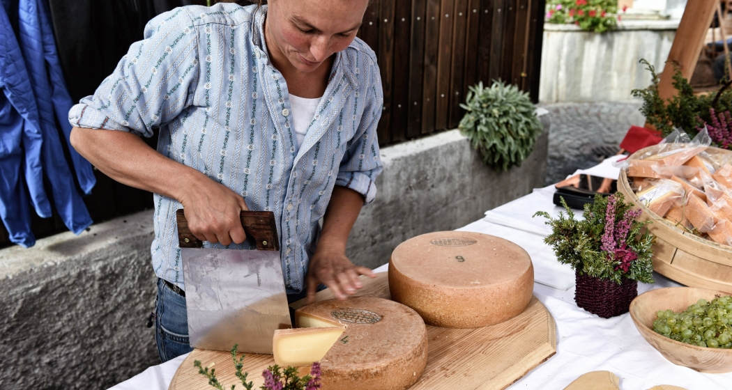 Bäuerin schneidet Alpkäse (© Ziitla.ch) Bäuerin schneidet Alpkäse am Markt vom Alp Spektakel
