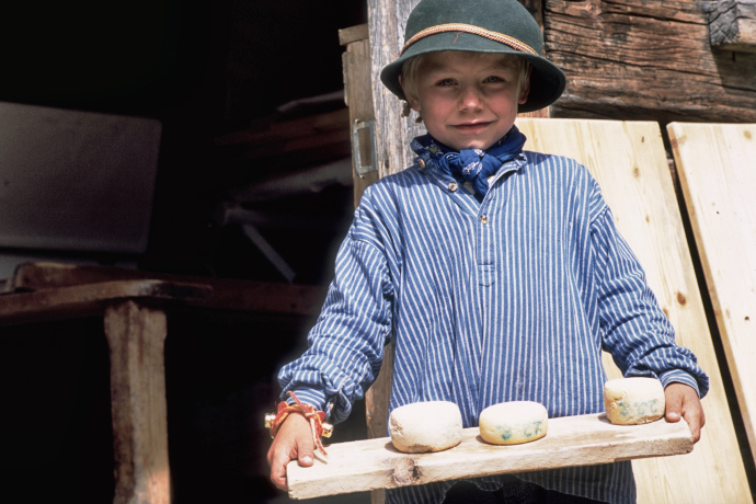 Junge präsentiert stolz den produzierten Alpkäse (© Peter Donatsch) Junge präsentiert stolz den produzierten Alpkäse