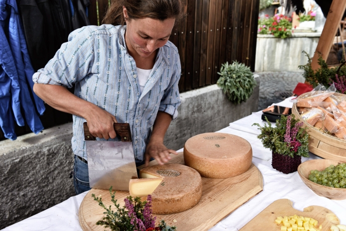 Bäuerin schneidet Alpkäse (© Ziitla.ch) Bäuerin schneidet Alpkäse am Markt vom Alp Spektakel